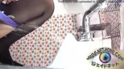 Asiatin in Strumpfhose hockt mit runtergezogenem Slip über dem Urinal und pinkelt kräftig.