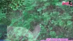 Junge Blondine in roter Lederjacke hockt breitbeinig im Wald und pisst