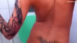 Nackte Blonde mit Tattoos spreizt Beine auf Toilette und hält pinken High Heel