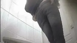 Frau in engen Jeans zieht Hose runter und zeigt nackten Po über Toilette
